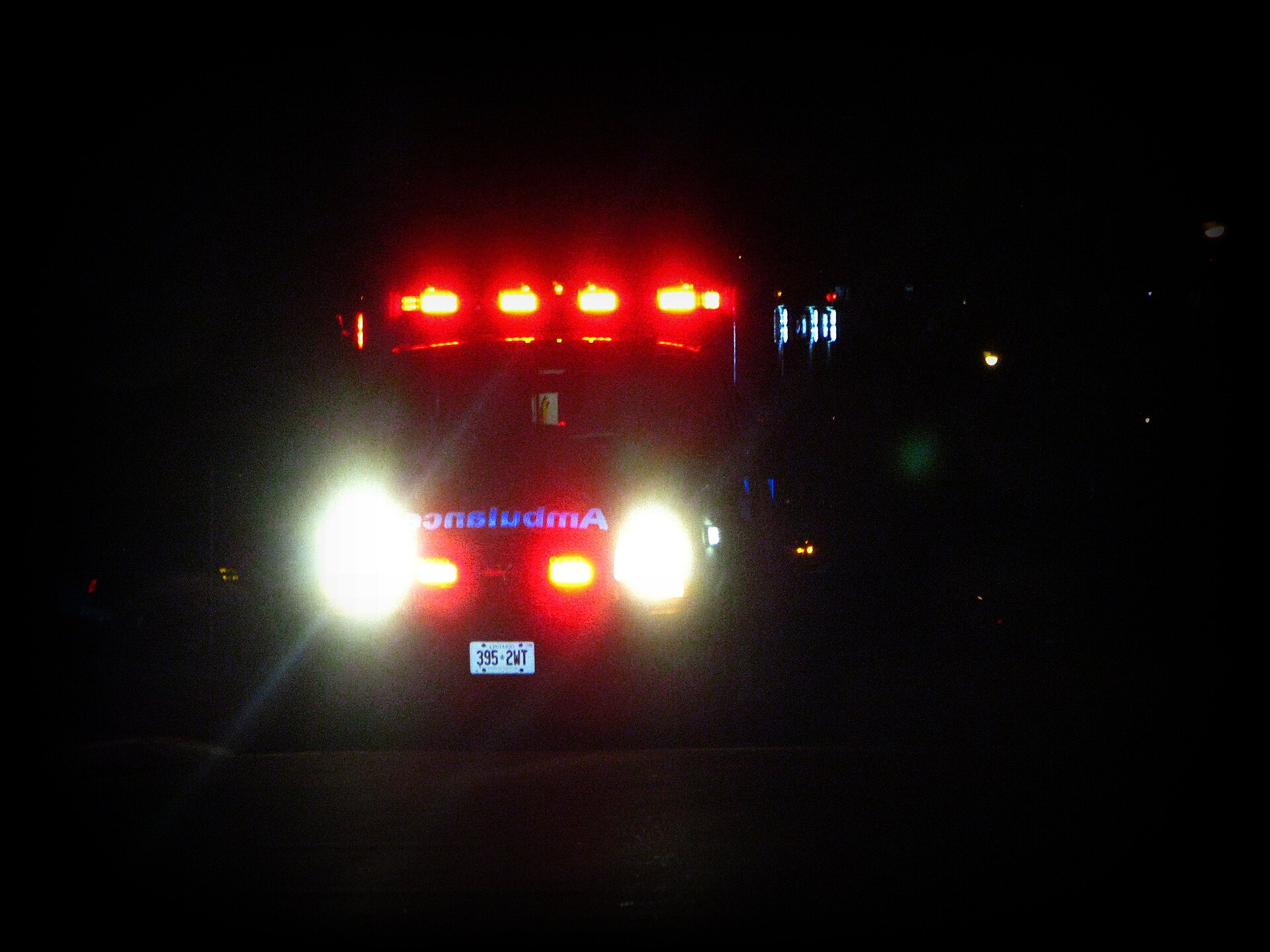 An ambulance with emergency lights on at night